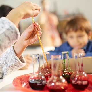 Kind experimentiert mit Reagenzgläsern
