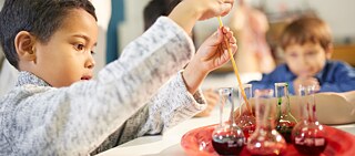 Kind experimentiert mit Reagenzgläsern