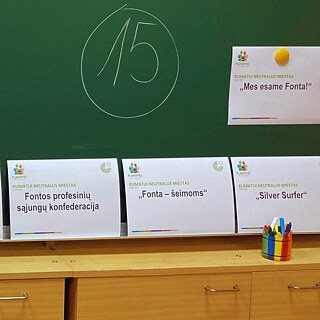 Neben der Schultafel liegen die Karten des Planspiels „Klimaneutrale Stadt“ bereit.