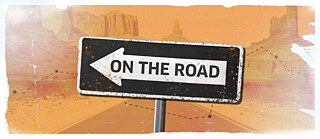 Einbahnstraßenschild mit der Aufschrift „ON THE ROAD” auf orangefarbenem, wüstenähnlichem Hintergrund