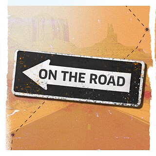 Einbahnstraßenschild mit der Aufschrift „ON THE ROAD” auf orangefarbenem, wüstenähnlichem Hintergrund