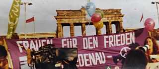 Frauenfriedenskette am Brandenburger Tor mit Eva Quistorp (ganz rechts im Bild) als Rednerin und Initiatorin und Luftballons über die Mauer, die von der Stasi aufgesammelt wurden