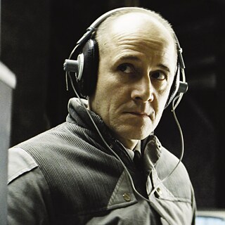 Ein Mann mit Kopfhörern vor schwarzem Hintergrund.