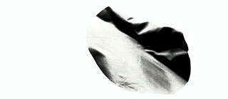 eine organisch wirkende, unregelmäßig geformte Schwarz‑Weiß‑Struktur vor komplett weißem Hintergrund zu sehen. Die Form wirkt wie ein abstrakter, leicht gefalteter oder verzerrter Oberflächenausschnitt mit weichen Hell‑Dunkel‑Verläufen.