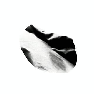 Auf dem Bild ist eine organisch wirkende, unregelmäßig geformte Schwarz‑Weiß‑Struktur vor komplett weißem Hintergrund zu sehen. Die Form wirkt wie ein abstrakter, leicht gefalteter oder verzerrter Oberflächenausschnitt mit weichen Hell‑Dunkel‑Verläufen. 