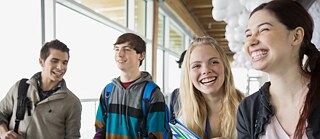 Mehrere Schüler unterhalten sich lachend auf dem Gang.