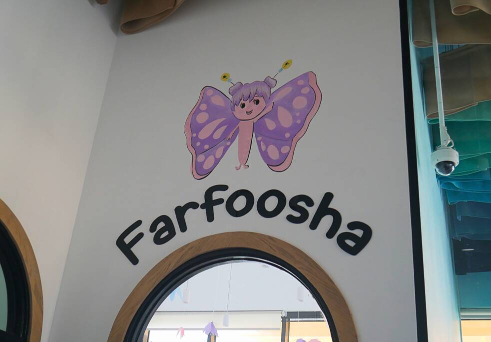 رسم توضيحي لطفل يرسم فراشة فوق مدخل. كُتبت كلمة "فرفوشة" أسفل الفراشة.