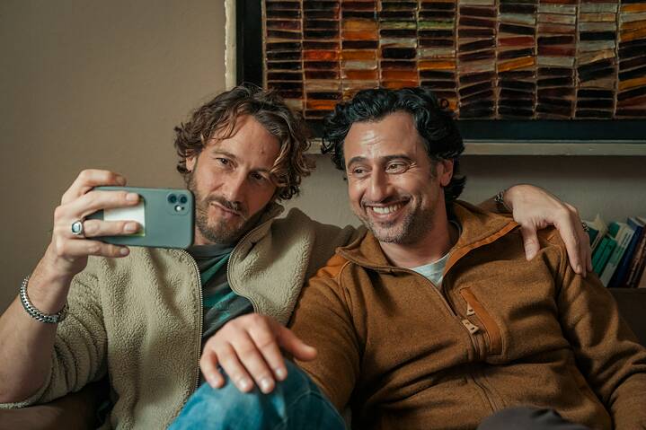 Still Frame from the Netflix Germany Series "Dudes": David Rott; Serkan Kaya are taking a selfie sitting on a sofa.
