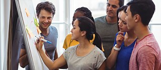 Eine Gruppe von Menschen, die an eine Tafel schreiben