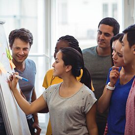 Foto von Lehrer*innen vor einer Tafel