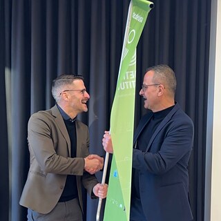 Dr. Wenzel Bilger (left) and Klaus Krischok holding a green flag of the Goethe-Institut 