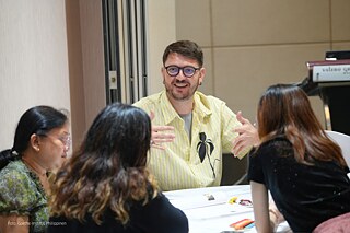 Der Workshop-Leiter Enes Karic spricht mit Teilnehmenden während eines Workshops.