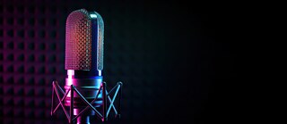 Eine junge Frau mit Kopfhörern wählt einen Podcast am Handy aus