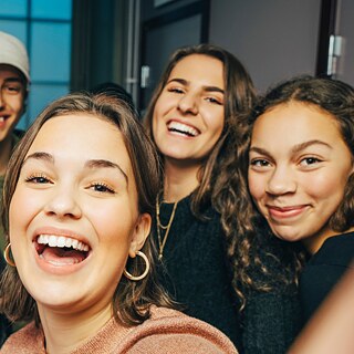 eine Gruppe junger Menschen nimmt ein Selfie auf.