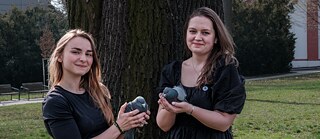 Two women holding pidgeons