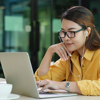 Woman sitting at desk with books and computer