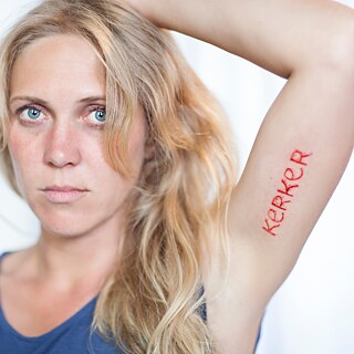 Woman who has the word Kerker tattooed on her Armauf dem Arm tätowiert
