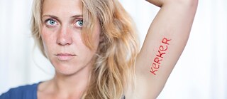 Woman who has the word Kerker tattooed on her Armauf dem Arm tätowiert