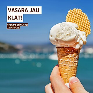Roka tur vafeļu konusu ar vienu saldējuma bumbiņu un vafeļu gabaliņu, fonā redzams izplūdis zils ūdens. Attēla kreisajā pusē ir teksts ‘Vasara jau klāt! Vasaras brīvlaiks: 22.06.–14.08.’