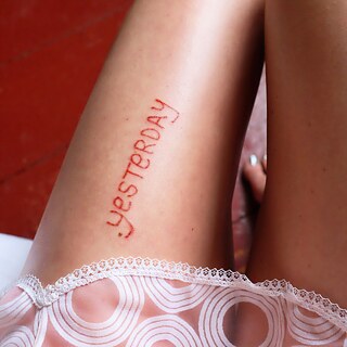 Leg with the word Yesterday as a tattoo