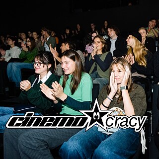 happy people sitting in the cinema and clapping