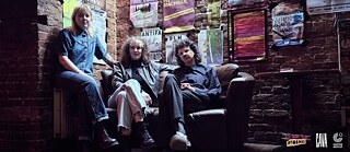 Members of the Band CAVA are sitting on a sofa