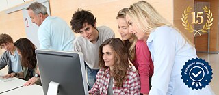 Vier junge Leute vor einem PC