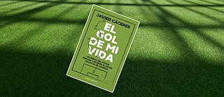 Portada del libro El gol de mi vida colocada sobre césped sintético verde. La portada, de color verde, muestra el título en letras blancas grandes y dibujos de flechas y jugadas de fútbol. En la parte superior aparece el nombre del autor, Javier Cáceres.