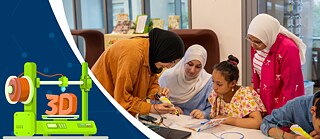 ورشة عمل حول الطباعة ثلاثية الأبعاد والتعلم الرقمي: يعمل عدة مشاركين معًا على مشروع باستخدام قلم طباعة ثلاثي الأبعاد، بينما يظهر على الجانب الأيسر رسم توضيحي لطابعة ثلاثية الأبعاد.