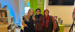 3 Praktikanten am Stand bei einer Karriere Roadshow am Goethe-Institut London in der Bücherei