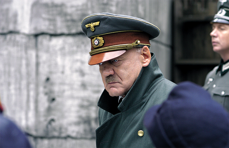 <b>„Der Untergang“</b> <br>Wie menschlich darf man Hitler darstellen? Mit <i>Der Untergang</i> widmete sich 2004 erstmals seit Ende des Zweiten Weltkriegs ein Film hauptsächlich der Figur Adolf Hitler und zeigte die letzten Tage im Führerbunker. Während der Film national wie international durchaus ein Kassenerfolg war, entbrannte in Deutschland insbesondere unter Historikern eine Diskussion, wie man Hitler im Film zeigen dürfe: Die einen waren überzeugt, dass es zur Entmystifizierung der Person beitrage, wenn Hitler auch Gefühle zeige. Andere sprachen sich vehement dagegen aus, so viel emotionale Nähe zuzulassen. Sowohl Produzent Bernd Eichinger als auch Hauptdarsteller Bruno Ganz erhielten den Bayerischen Filmpreis, <i>Der Untergang</i> erhielt zudem eine Oscar-Nominierung als bester fremdsprachiger Film.