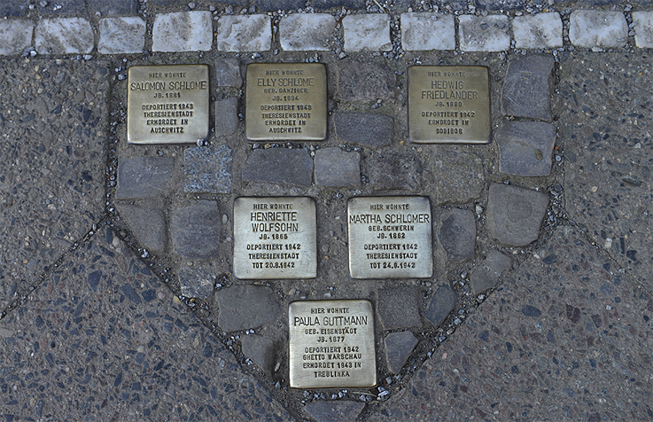 <b>Stolpersteine (stumbling stones)</b> <br>A small commemorative plaque in front of every house in which the persecuted or deported once lived: since 1992, artist Gunter Demnig has been installing his <i>stolpersteine</i>, pavers topped by a brass plate that commemorate the victims of National Socialism. Each stone is inscribed with "Hier lebte" (here lived), followed by the name, and date and place of death of a person murdered by the Nazis. The stones are set in the pavement in front of their last place of residence. What began as a small art project has now spread to 21 European countries, making <i>stolpersteine</i> Europe's largest decentralized memorial.