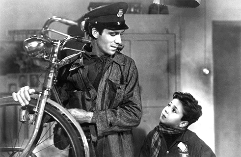 <b>„Zloději kol“, Vittorio de Sica (1948)</b><br>Jako reakce na fašistickou diktaturu Benita Mussoliniho v Itálii vznikla v polovině 40. let umělecká epocha italského neorealismu. Inspirováni poetickým realismem a marxismem se spisovatelé a režiséři snažili o autentické zobrazení reality života ve válkou zničené Evropě. <i>Zloději kol</i> Vittoria de Sicy jsou ukázkovým příkladem tohoto hnutí: Otec pracuje jako námezdní dělník, aby uživil sebe a svou rodinu. Když si konečně najde práci jako lepič plakátů, je mu ukradeno kolo. Sám se pak stane zlodějem – a to má vážné následky. De Sica zpochybňuje nemilosrdnou kapitalistickou třídní společnost, která staví nejchudší proti sobě, a vyzývá k solidaritě mezi lidmi.