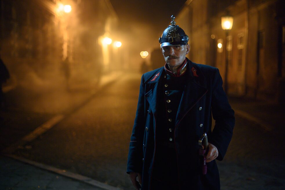 Inspector Kiss  (Georg Friedrich) walking the street alone at night in full uniform.