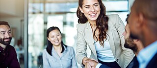 Two business people shaking hands during a meeting in the office
