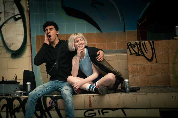 Standbild aus der Netflix Germany original series "We are the wave"  Rahim (Mohamed Issa) und Paula (Sarah Mahita) kommen sich in der verlassenen Fabrik näher.