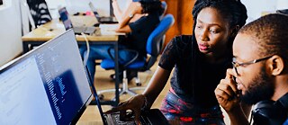 Woman and man sitting in front of monitor